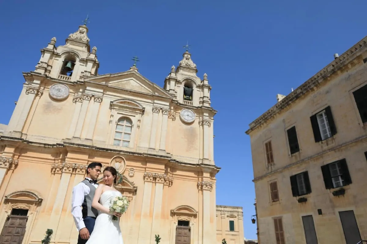 マルタの石造建築を背景にしたドレス姿